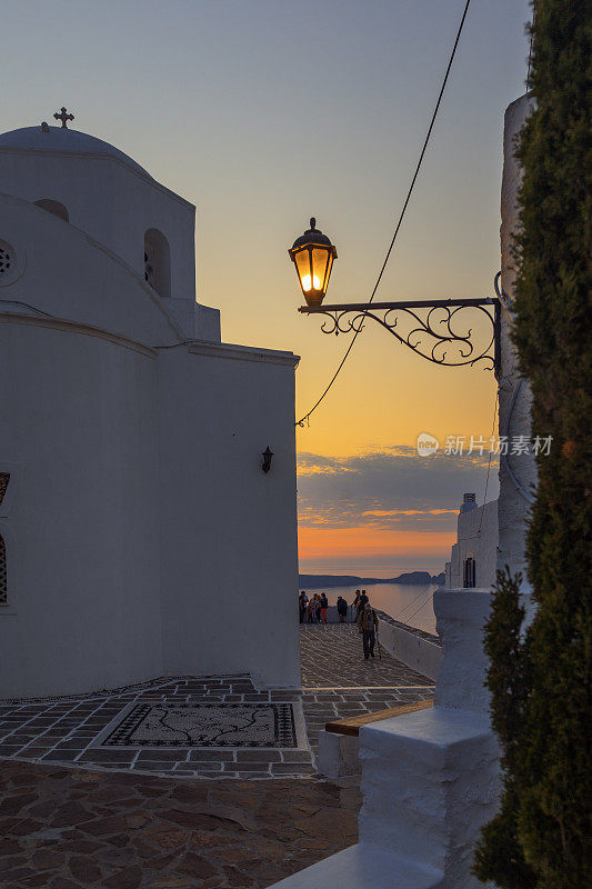从位于希腊基克拉迪群岛米洛斯岛普拉卡村的Panagia Korfiatissa教堂观看日落。